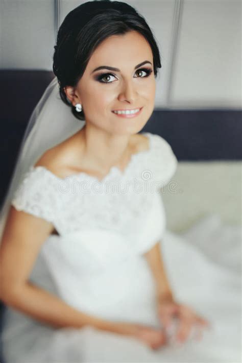 Brunette Bride Smiles Sitting On The White Bed Stock Photo Image Of Dress Light 92894296