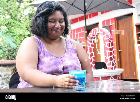 jährige Brünette Latina trinkt einen Azulito Cocktail oder ein alkoholisches Getränk mit