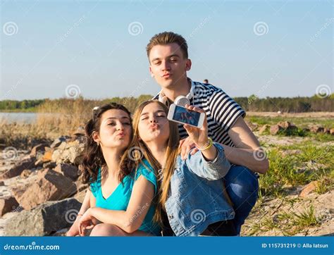 Junge Leute Mann Und Zwei Frauen Brunette Und Das Blonde Nehmen Ducken Sich Stockbild Bild