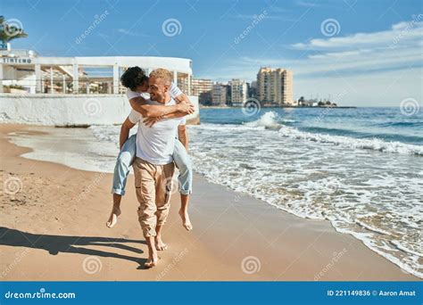 Lovely Gay Couple On Piggyback Ride At The Beach Stock Photo Image Of Cheerful Outdoors