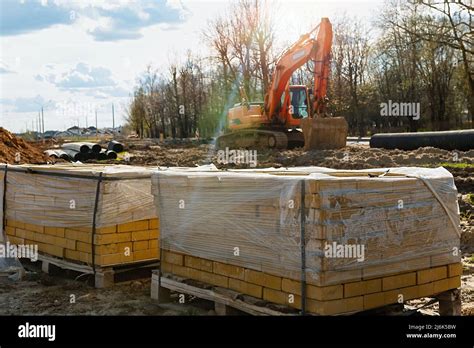An Excavator With A Bucket Digs A Trench For Laying Pipes Construction