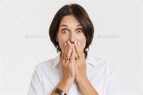 Mature Brunette Woman Expressing Surprise While Covering Her Mouth Stock Photo By Vadymvdrobot