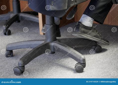 The Legs of an Office Clerk or Dispatcher on Duty Sitting on a Pneumatic Chair with Wheels ...