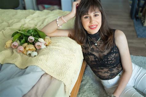 Perfect Brunette Woman With Perfect Skin Big Full Lips Posing At Bedroom Wearing Top Stock