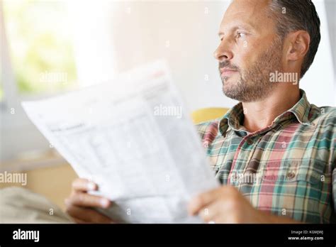 Cheerful Mature Man Reading Newspaper At Home Stock Photo Alamy
