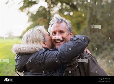 Portrait Happy Playful Mature Couple Hugging In Park Stock Photo Alamy