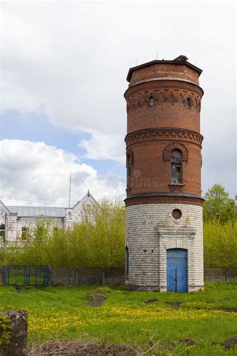 Ancient Water Tower Made Of Bricks Against A Cloudy Sky Stock Photo