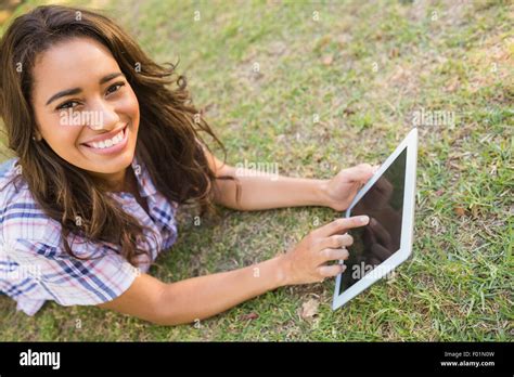 Pretty Brunette Lying In The Grass And Using Tablet Stock Photo Alamy