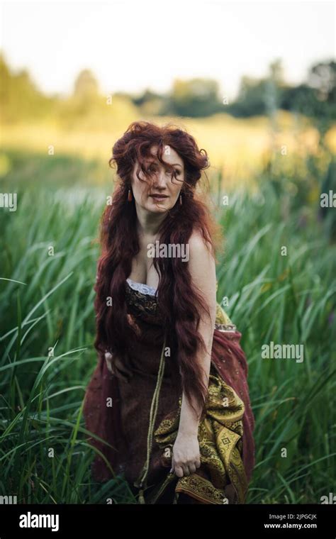 Portrait Of A Beautiful Mature Woman Dressed In A Nymph Style Dress Woman With Long Red Hair On