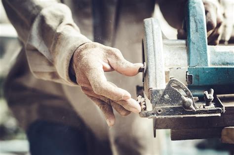 Premium Photo Midsection Of Carpenter Using Circular Saw On Wood