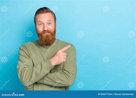 Photo Of Funny Optimistic Guy With Red Hairstyle Dressed Khaki Long Sleeve Directing Empty Space