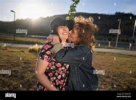 A Beautiful Latina Mother Kisses Her Daughter In A Park Near The City Stock Photo Alamy