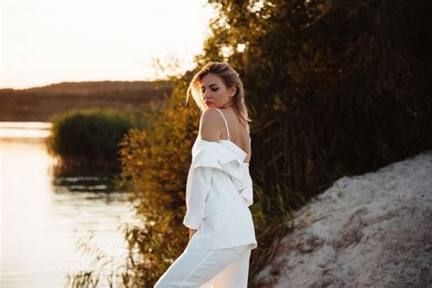 Premium Photo Side View Of Gorgeous Blonde In White Suit Standing Near Lake During Summer