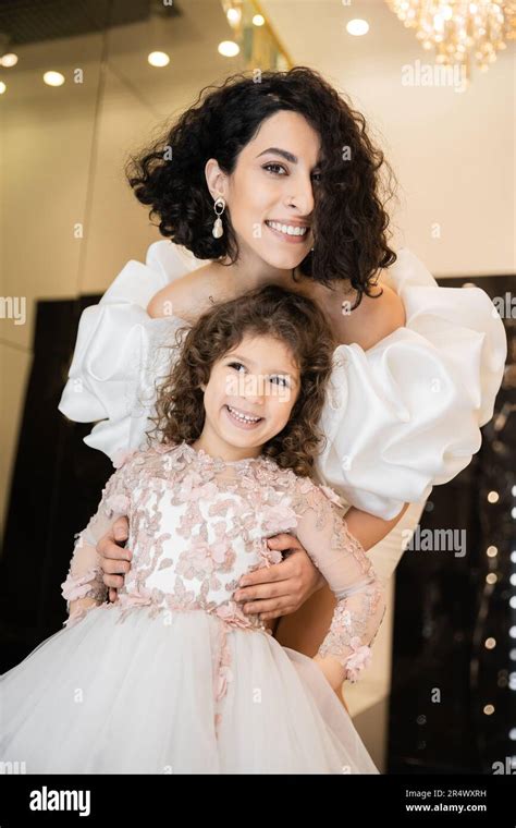 Gorgeous Middle Eastern Bride With Brunette Hair Standing In White Wedding Dress With Puff