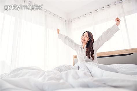 Happy Fresh Asian Woman Stretching In Bed Waking Up Happy Concept