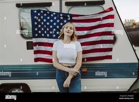 Une jeune femme blonde espagnole qui pose près d une remorque de camp Avec un drapeau américain