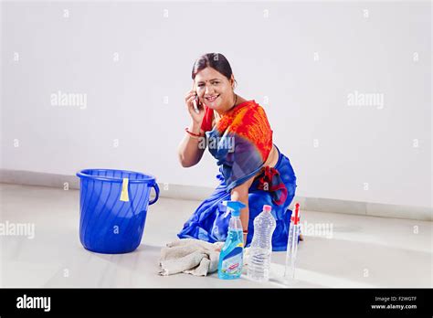 1 Indian Adult Woman Housewife Cleaning Floor And Talking Mobile Phone