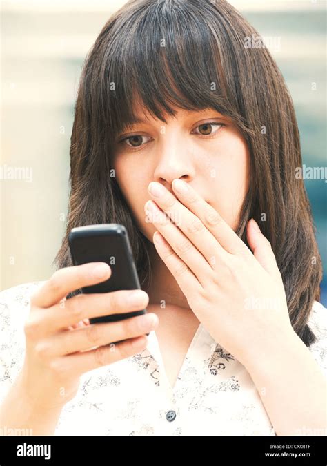 Young Woman Reading A Text Message Looking Shocked Stock Photo Alamy