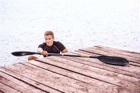 Canoeist Man Sitting In Canoe Holding Paddle Getting Out Of Water