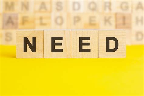 Premium Photo | The word need is written on wooden cubes on a bright