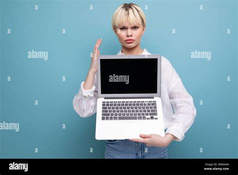 Jeune Femme Blanche Blonde Avec Une Coupe Courte V Tue D Une Chemise Blanche Et Un Jean Tient Un