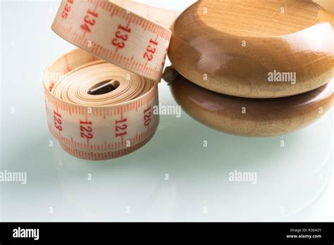 Yo-yo effect in diet concept. Wooden yoyo with centimeter measure ...