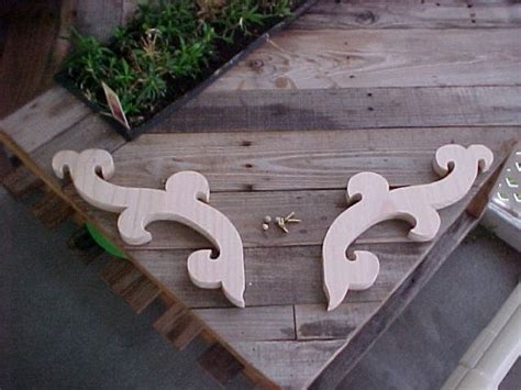 two wooden carvings sitting on top of a wooden table next to a planter ...