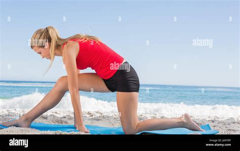 Fit Blonde Stretching Leg On Exercise Mat On The Beach Stock Photo Alamy