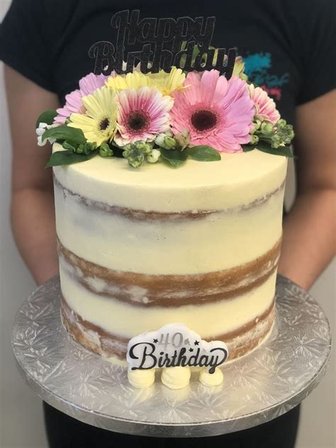 Cream Naked Cake With Pastel Fresh Flowers And Topper The Girl On The Swing