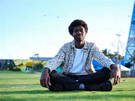 Image Of Man Sitting Cross Legged In A Park Austockphoto