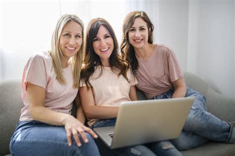 Smiling Best Girl Friends Blond And Brunette Sit On Sofa With Laptop Stock Photo Image Of