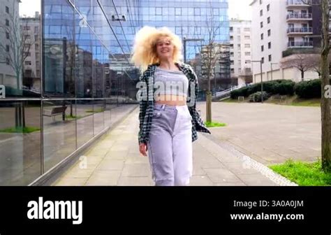 Energetic Blonde Woman Dancing Freely In A Modern Urban Setting Showcasing Dynamic Movements