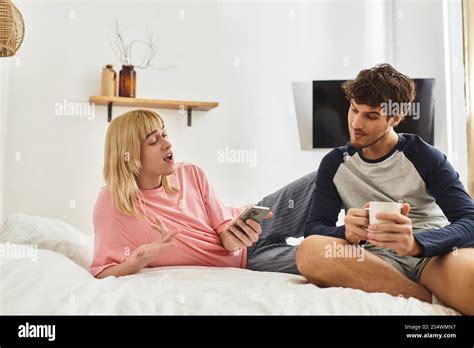 A Loving Gay Couple Shares Laughter And Joy While Relaxing Together On A Comfortable Bed Stock