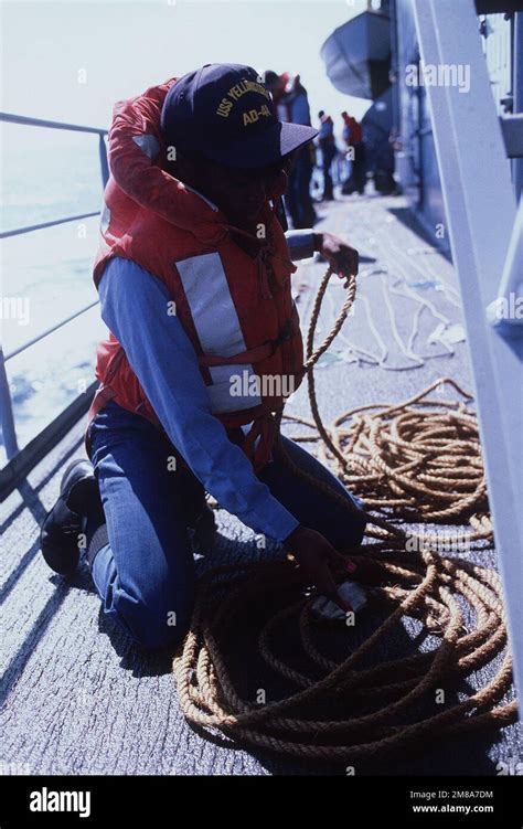 A Female Crew Member Coils Line For A Highline Operation Aboard The