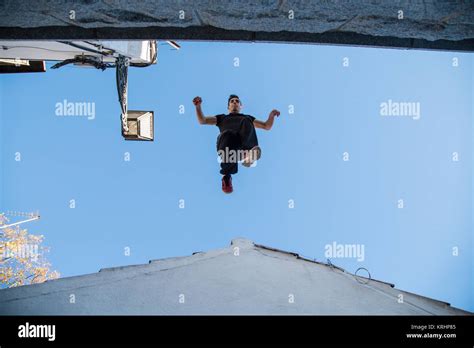 Young man doing impressive parkour jump from one roof to another Stock ...