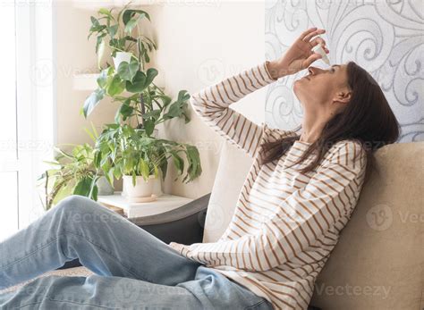 Head shot young caucasian woman using medical eyes drops suffering from