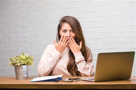 Retrato De Joven Estudiante Mujer Latina Sentada En Su Escritorio Sorprendida Y Sorprendida