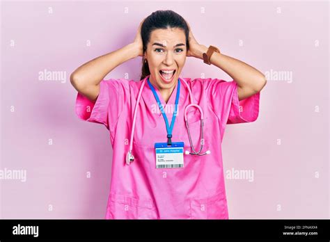 Jeune femme brunette portant l uniforme de médecin et le stéthoscope fou et effrayés avec les