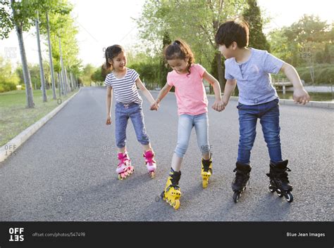 Happy children roller skating stock photo - OFFSET