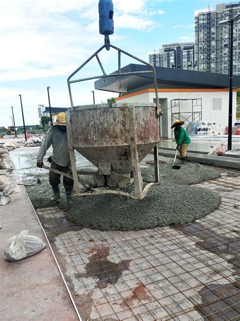 Group Of Construction Workers Pouring Wet Concrete Using The Mobile