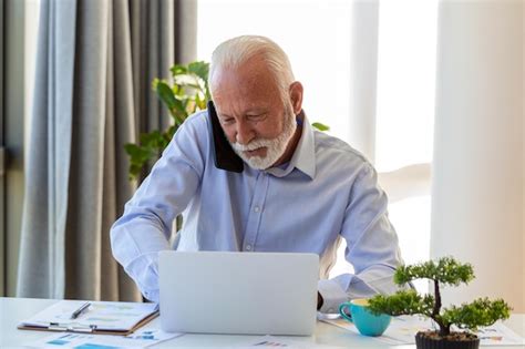 Premium Photo Mature Businessman Working On Laptop And Talking On Cellphone Handsome Mature