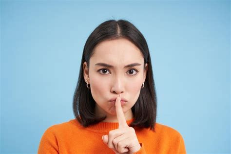 Free Photo Close Up Of Angry Brunette Asian Girl Shush Touches Lips With Finger Tells To Be