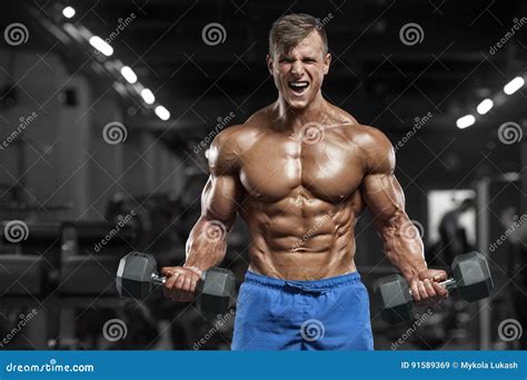 Muscular Man Working Out In Gym Doing Exercises With Dumbbells Strong Male Naked Torso Abs