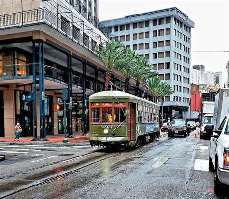 A Trolley Car Traveling Down A Street Next To Tall Buildings