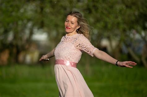 Premium Photo A Beautiful Elderly Blonde Woman In A Romantic Dress Opened Her Arms And Enjoys