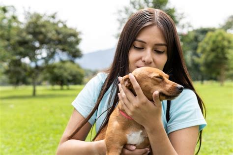 Una Mujer Adulta Joven Latina Acaricia A Su Pinsher Hembra En El Parque Foto Premium