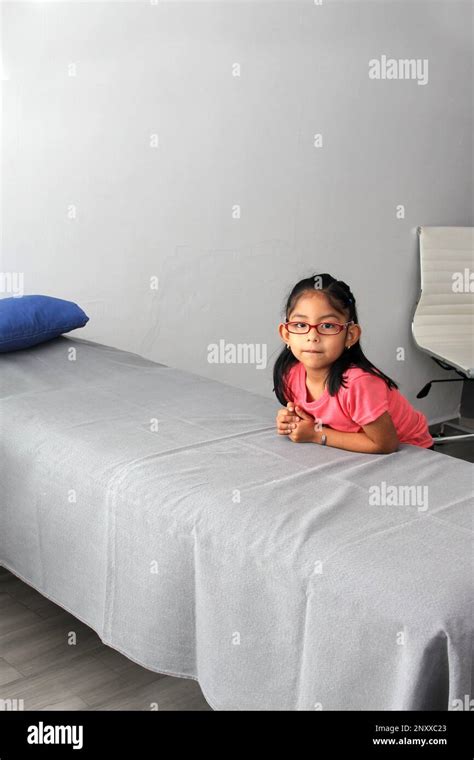 4 Year Old Brunette Latina Girl Sitting On The Bed In A Doctor S Office Nervous Scared Because