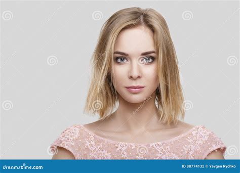 Portret Van Mooie Blonde Vrouw Met Kort Haar In Roze Cocktailkleding Op Grijze Achtergrond Stock