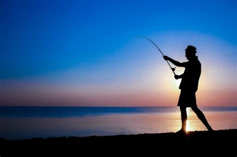 Um pescador feliz pescando peixes à beira mar em uma viagem de silhueta