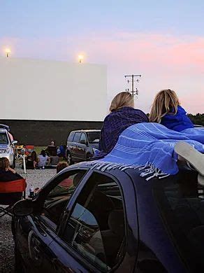 people sitting in chairs watching a movie at the drive - in theater ...